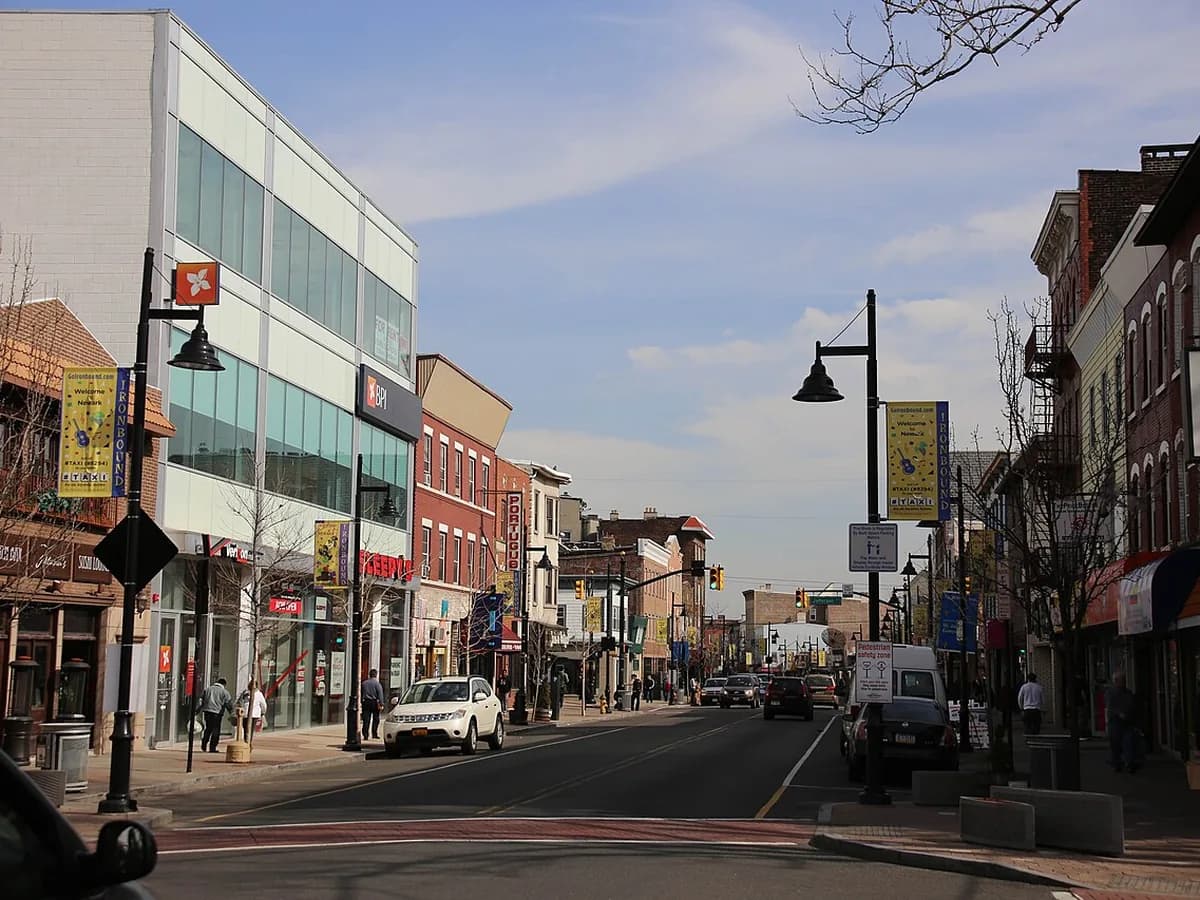 Vista da Ferry Street, no bairro Ironbound em Newark, com comércio dos dois lados da rua e bandeirolas nos postes