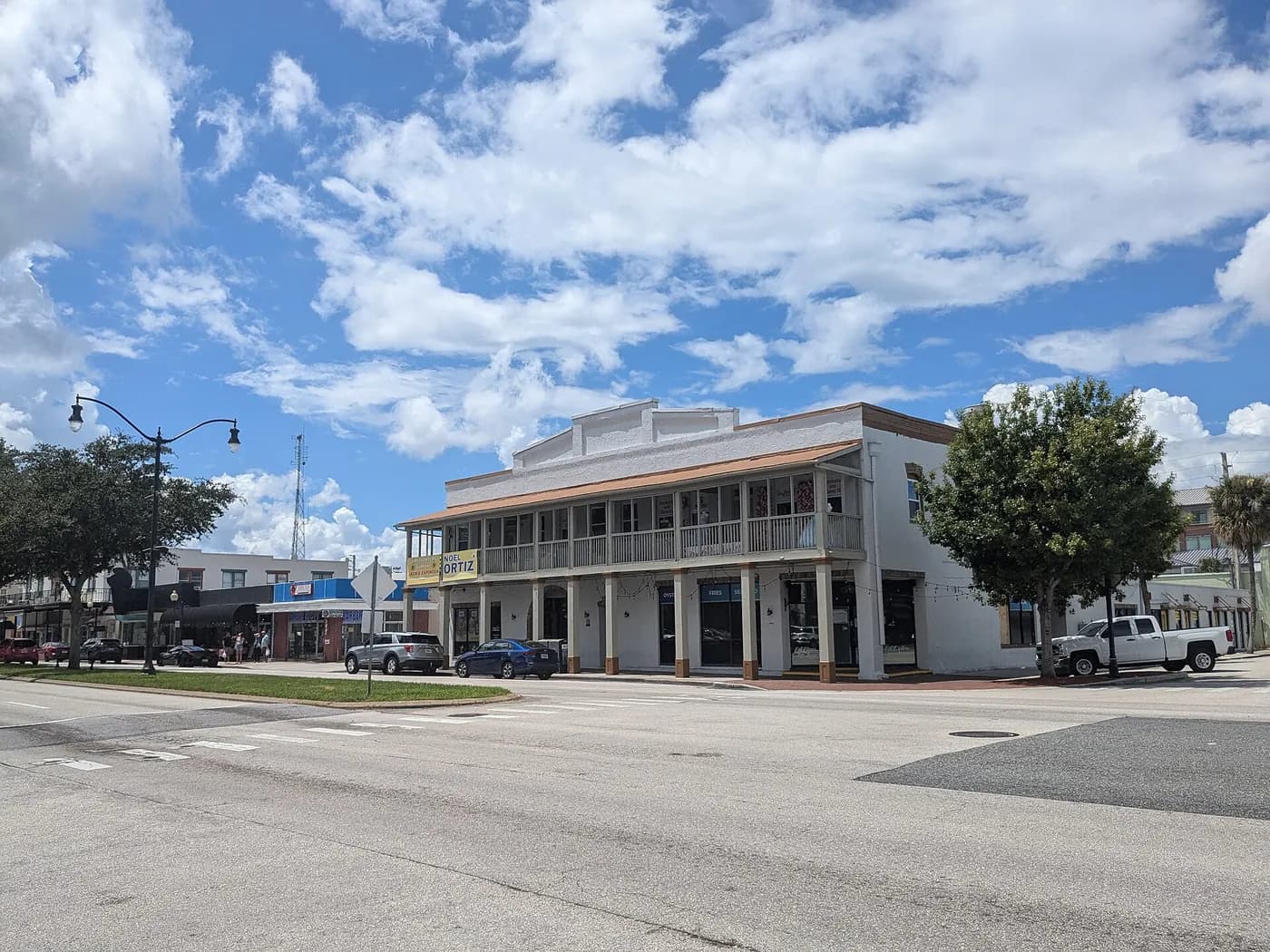 Vista da Broadway Avenue em Kissimmee, com prédios comerciais de dois andares e carros estacionados